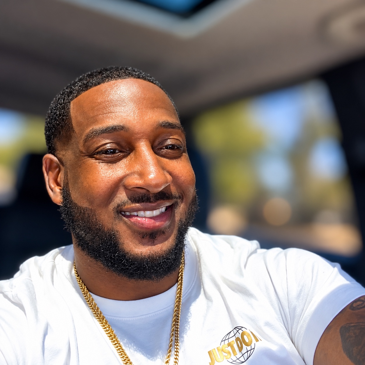 Devin Mooring smiling, wearing a white T-shirt and gold chain
